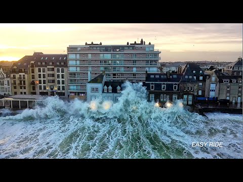 A drone films waves crashing over buildings